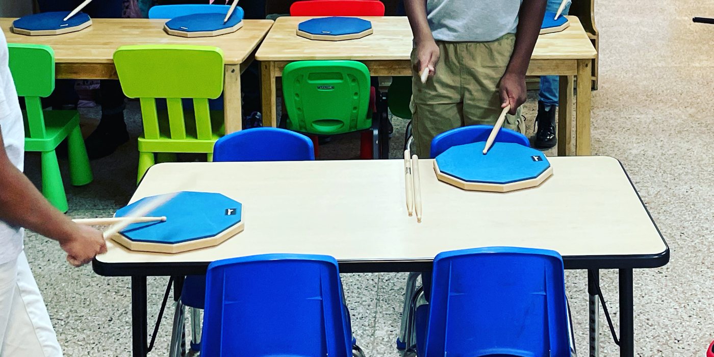 Practice pads and drumsticks on classroom tables during a percussion lesson